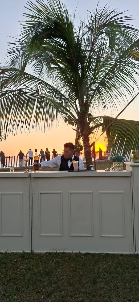 Carlos Ramírez preparando un cóctel en la barra durante una boda al atardecer